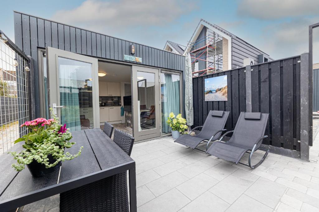 a patio with a table and chairs on a building at Vakantiewoning Bed & Bernard in Domburg
