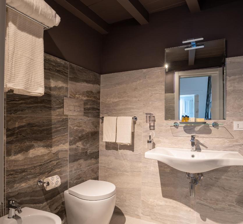 łazienka z umywalką, toaletą i lustrem w obiekcie ORTIGIAdreamrooms 14 w Syrakuzach
