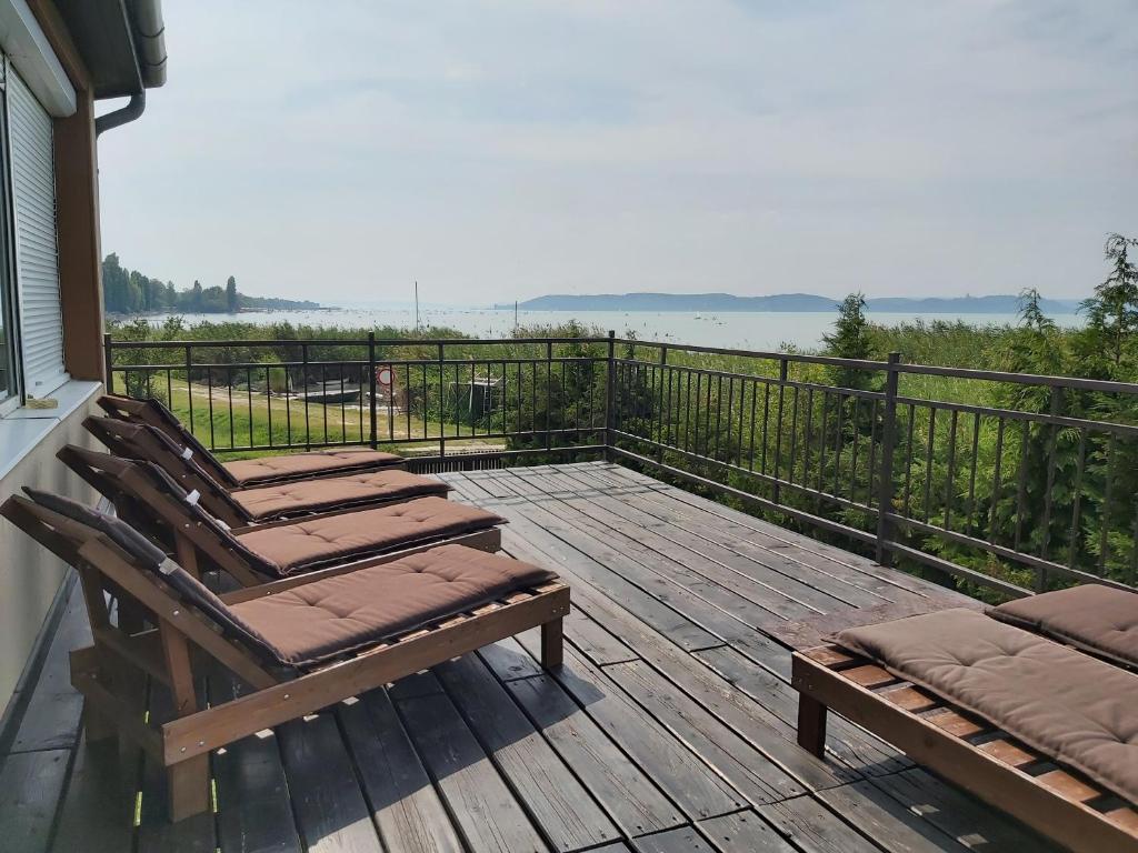 a deck with lounge chairs and a view of the water at Villa Klapka in Zamárdi