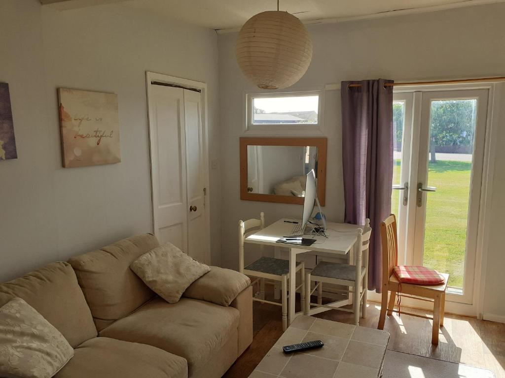 a living room with a couch and a desk with a computer at Mablethorpe Chalet in Mablethorpe