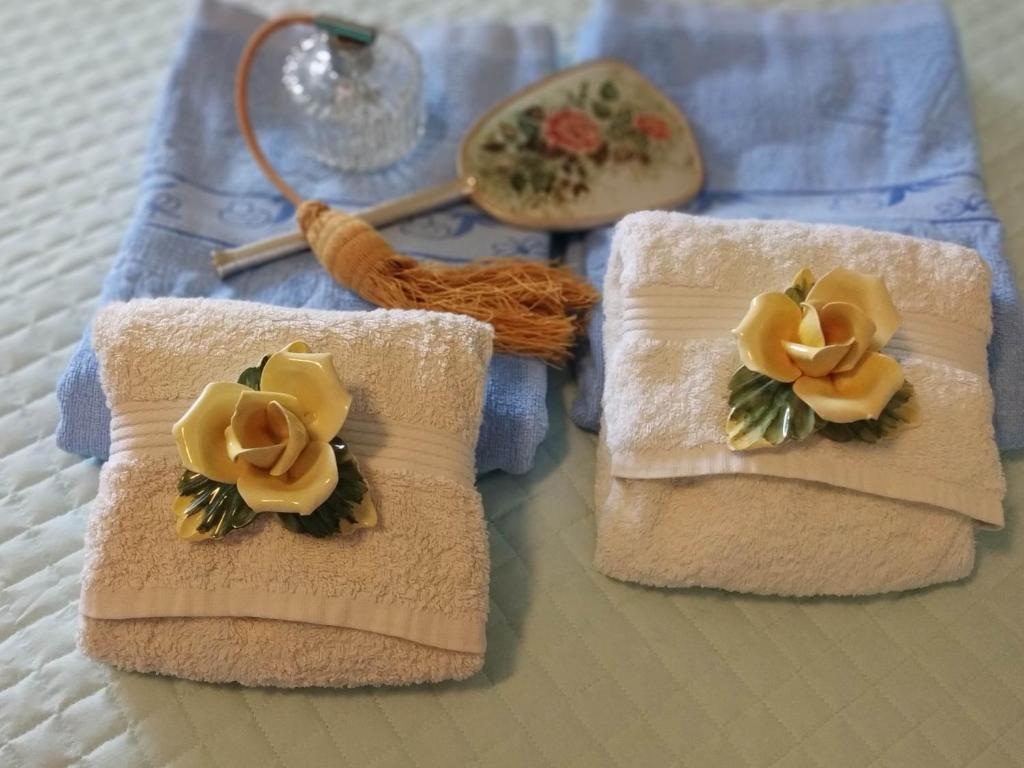 two towels with flowers on them on a table at Ellina's Home - Euboea island Greece in Oxílithos
