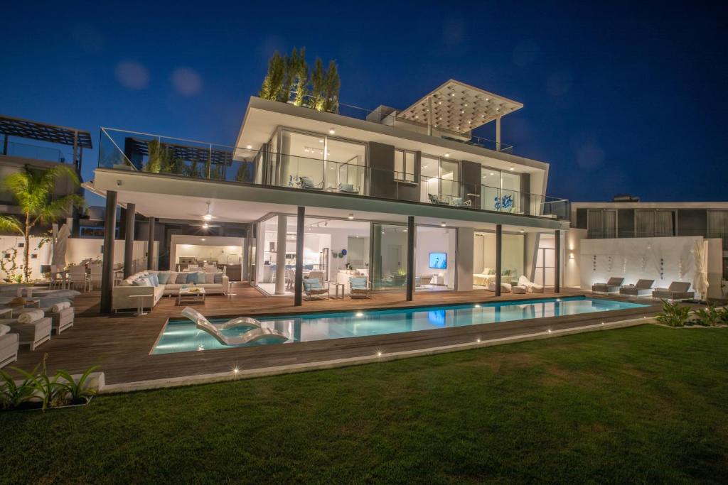 a large house with a swimming pool in front of it at Villa Olivine Pearl 3 in Protaras