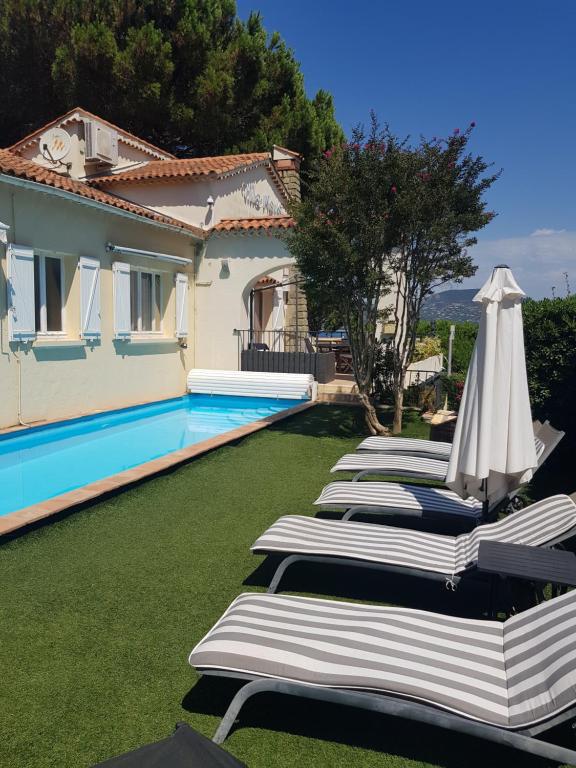 a row of chaise lounge chairs next to a swimming pool at Hotel Villa Maya in Saint-Tropez