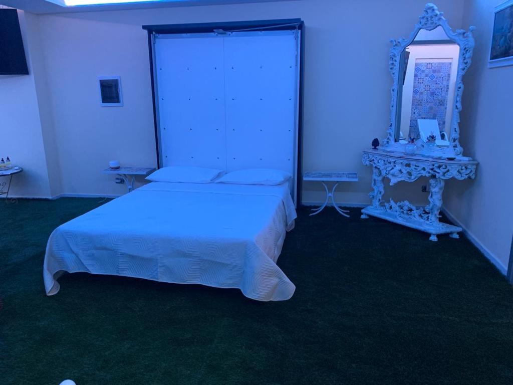 a bedroom with a white bed and a mirror at CAPRICCIO Di PASTA SPA CAMERA LUXURY in Gragnano