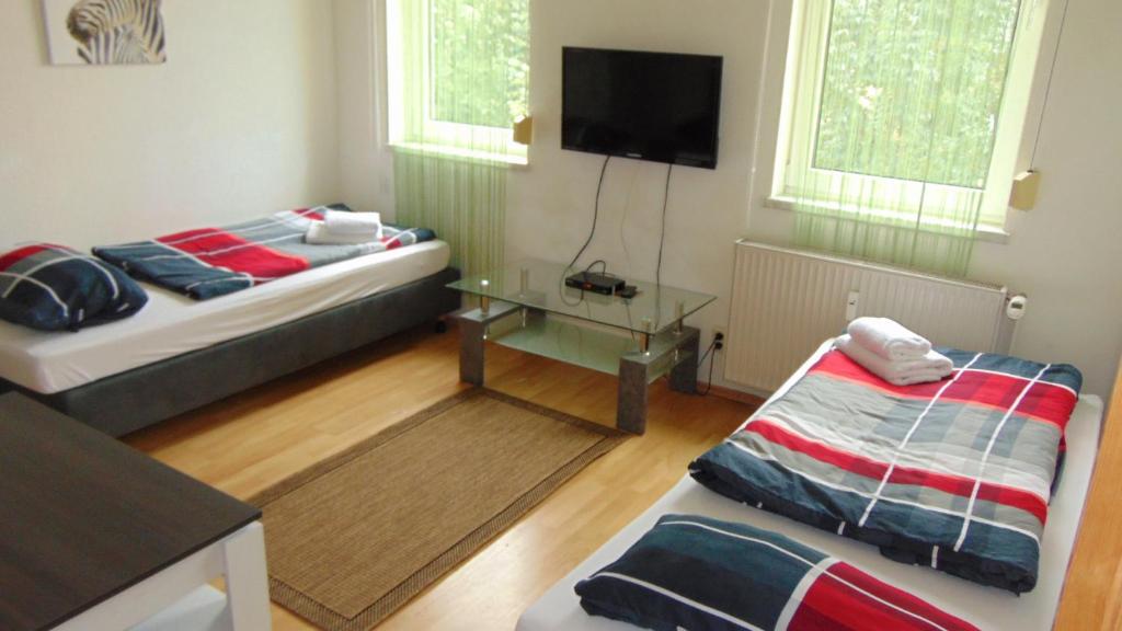 a room with two beds and a flat screen tv at Hostel Schützenbrücke in Quedlinburg