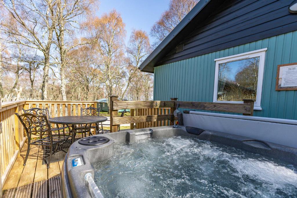 a hot tub on the deck of a house at Bracken Lodge 6 with Hot Tub in Belladrum