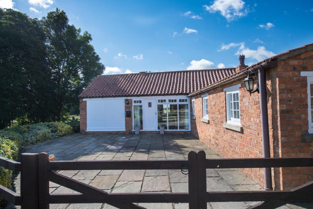 een vrijstaand huis met een groot terras ervoor bij The Coach House in Martin