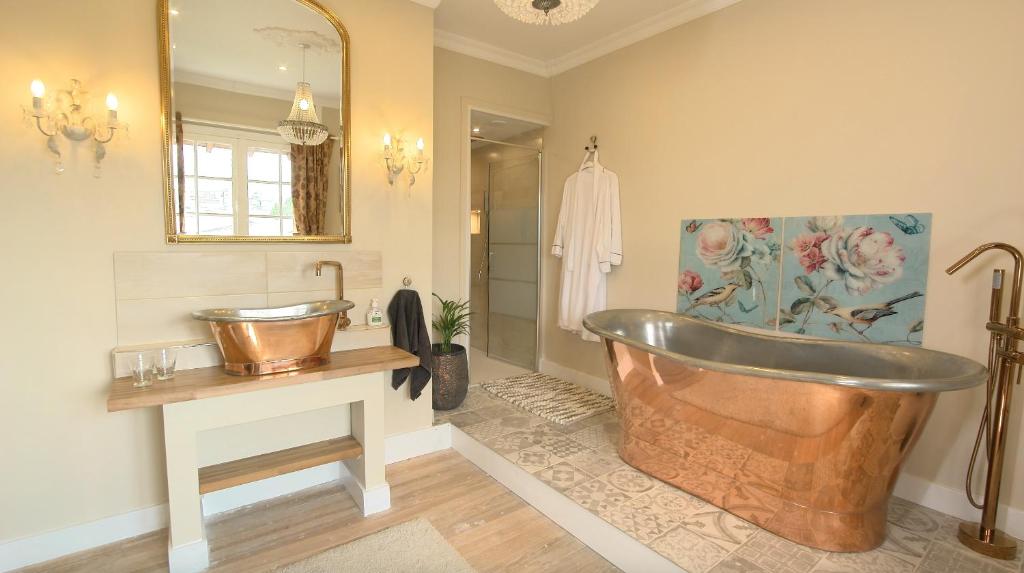 La salle de bains est pourvue d'une baignoire en cuivre et d'un lavabo. dans l'établissement R & R BERGERAC, à Bergerac