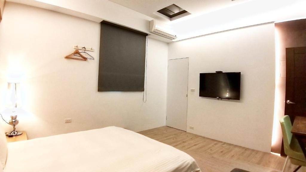 a bedroom with a bed and a tv on the wall at Pure House B&amp;B in Ji&#39;an