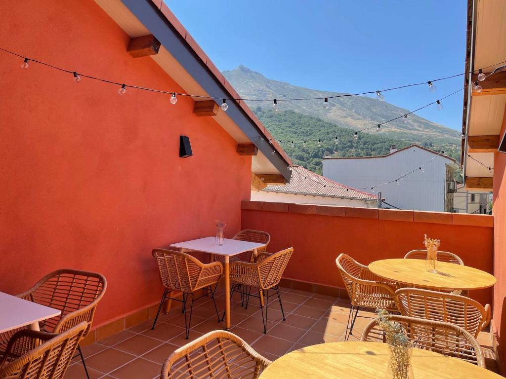 eine Terrasse mit Tischen und Stühlen auf dem Balkon in der Unterkunft Hotel Camino de las Estrellas in Serranillos