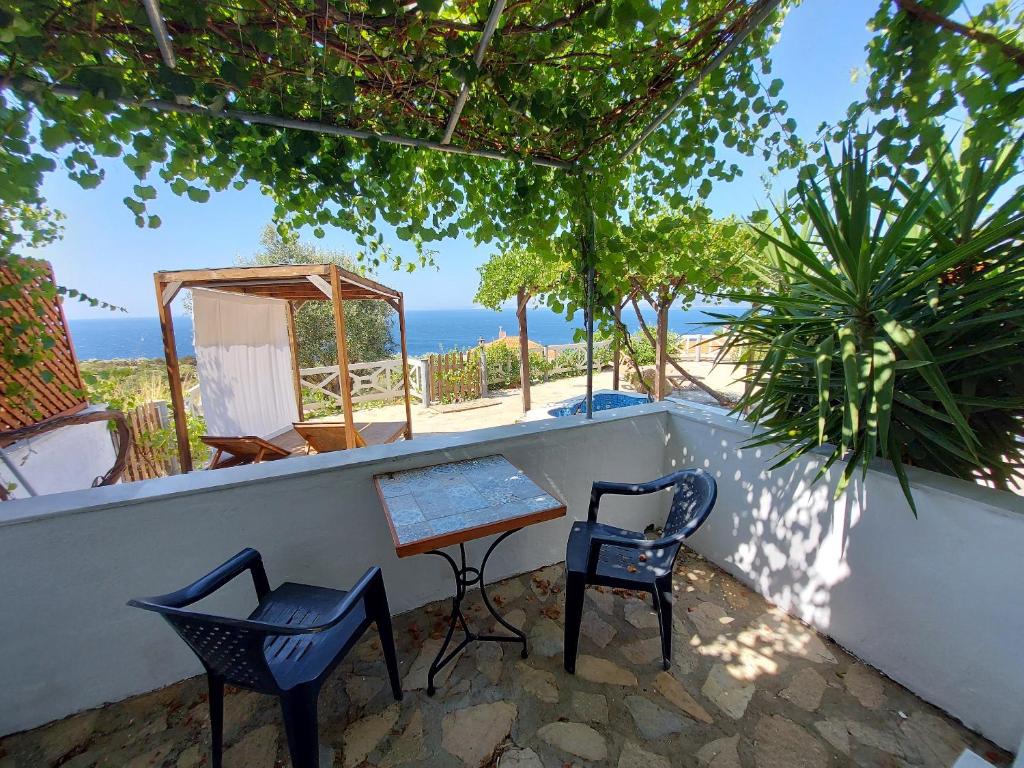 a table and two chairs on a balcony with the ocean at Beautiful house located on a hill with a spectacular sea view in Samos Island in Koumeika