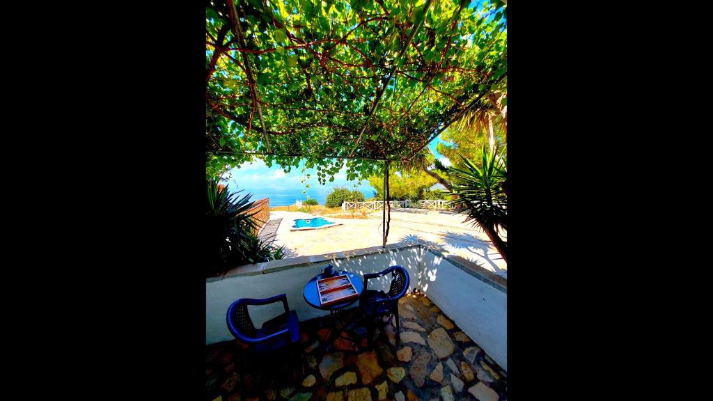 a view of a pool and a table and chairs at Beautiful house 800m from Koumeika, Samos in Koumeika