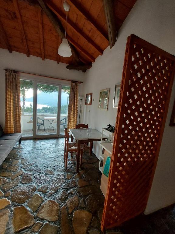 salon ze stołem i kamienną podłogą w obiekcie Beautiful house wiht sea view in Samos Island w mieście Koumeika