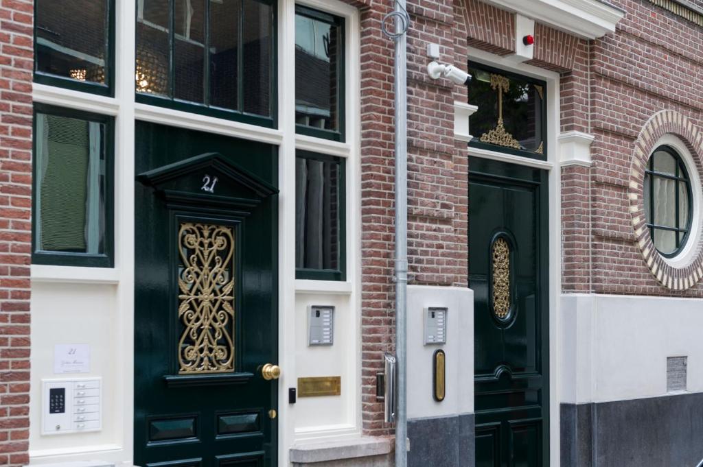 un edificio de ladrillo con una puerta y ventanas negras en Golden Mansion Aparthotel en Ámsterdam