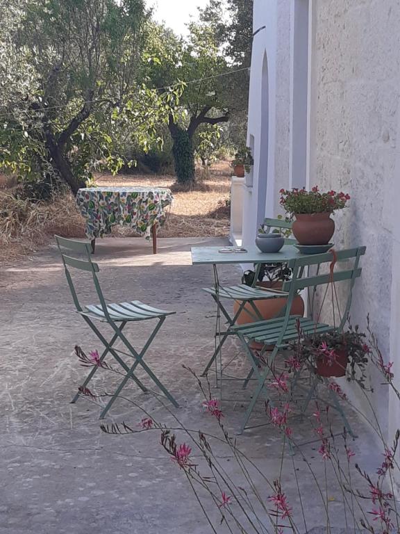 un patio con 2 sillas, una mesa y un banco en Casa Baronessa, en Ceglie Messapica