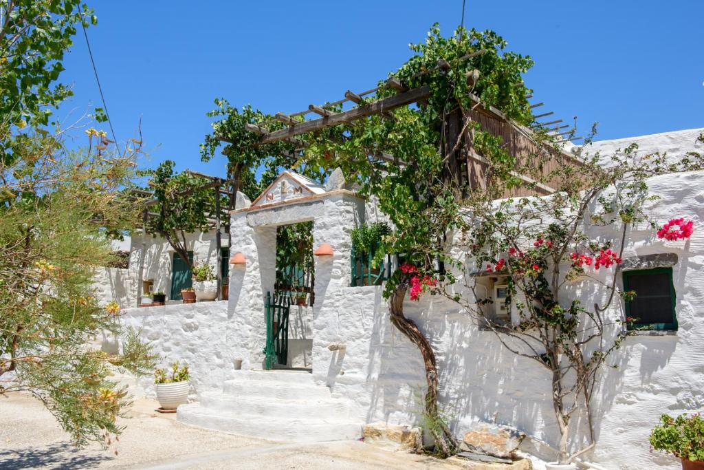 un edificio blanco con escaleras y flores. en Itonia House en Amorgos