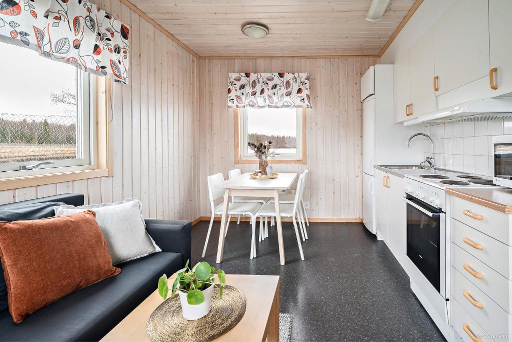 a small kitchen and living room with a couch and a table at First Camp Björknäs-Boden in Boden