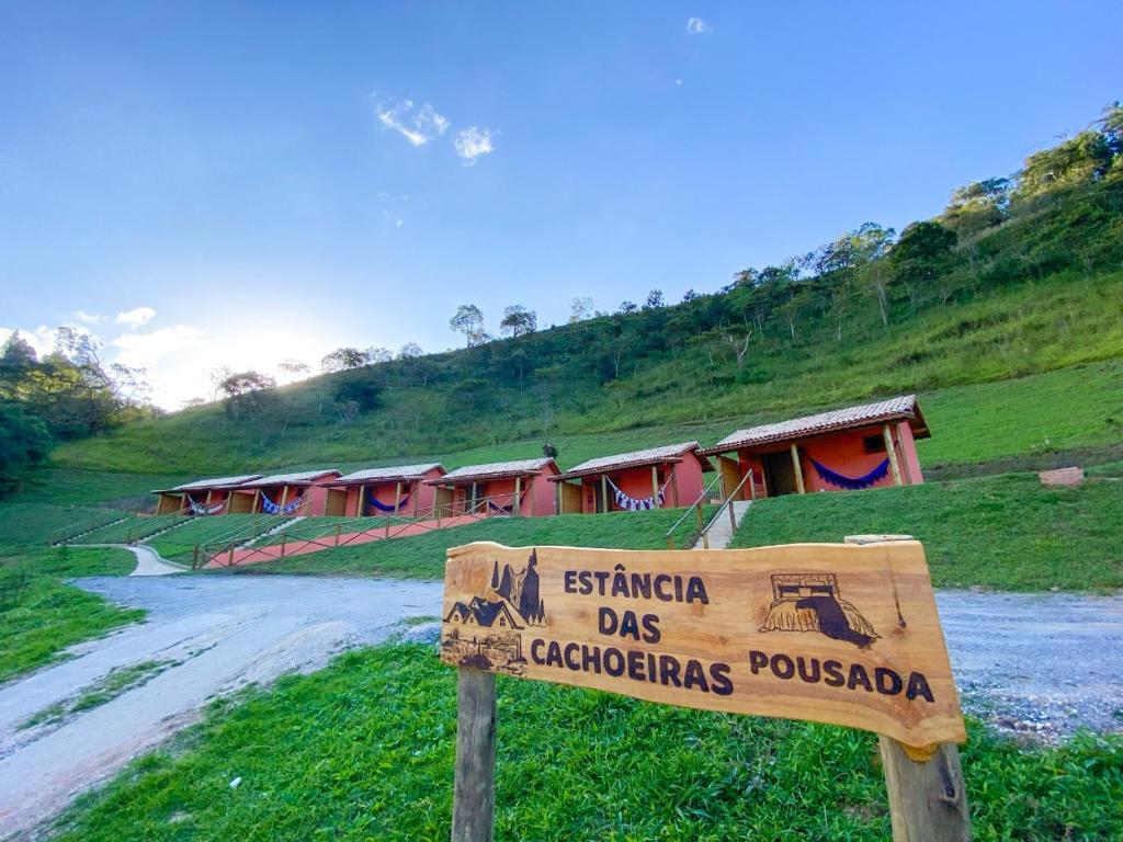 um sinal em frente a uma estrada de terra com casas em POUSADA ESTÂNCIA DAS CACHOEIRAS em Cunha