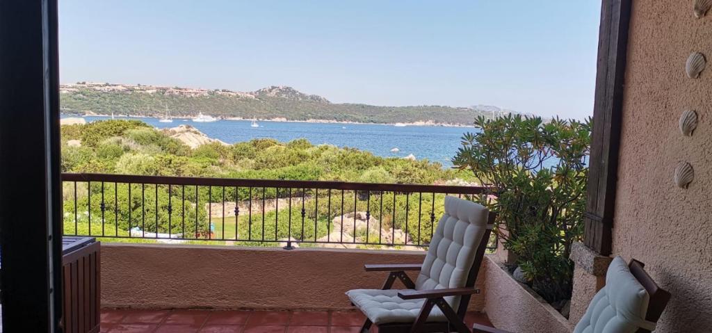 een balkon met een stoel en uitzicht op het water bij Casa Pedra Concada in Marinella