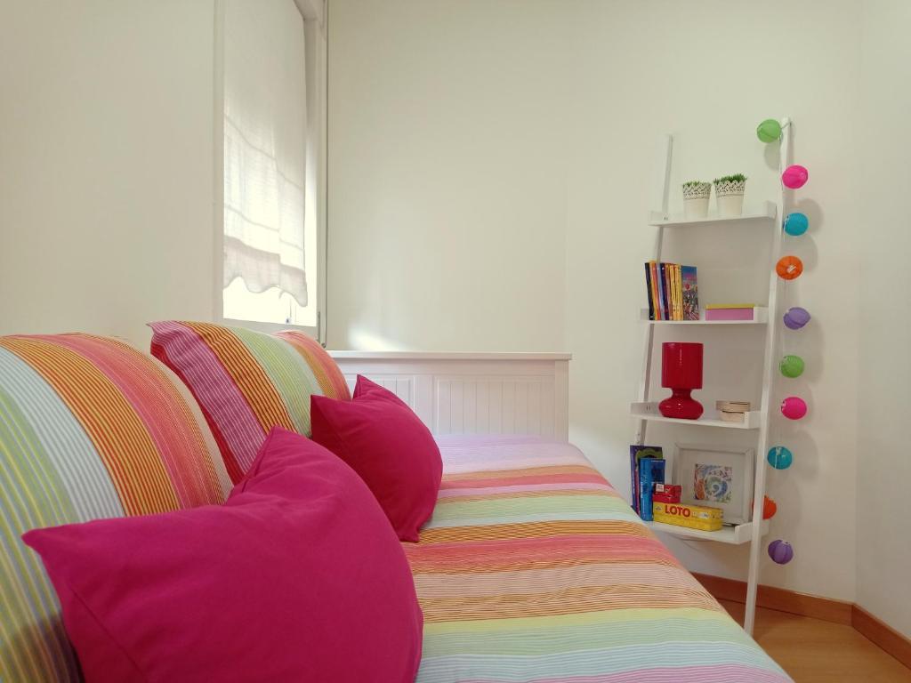 un sofá a rayas con almohadas coloridas en una habitación en Cerqueira's House, en Vila Nova de Cerveira