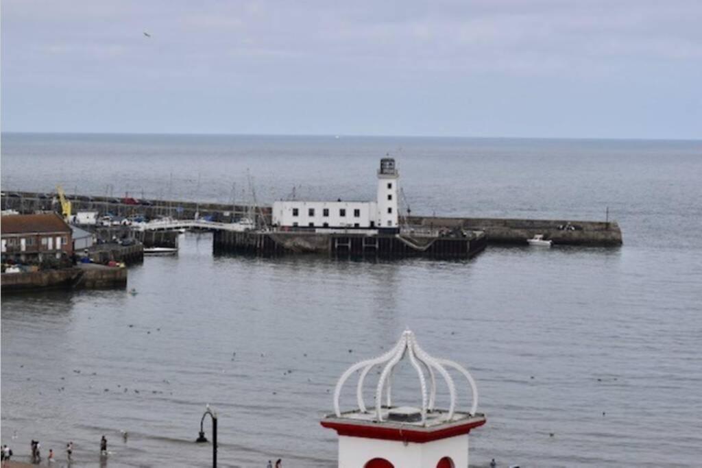 ein Leuchtturm im Wasser neben einem Wasserkörper in der Unterkunft Lighthouse View - Amazing sea and beach view - Free Sky TV including Sports and Movies - Fast WIFI - Free Private Parking in Scarborough