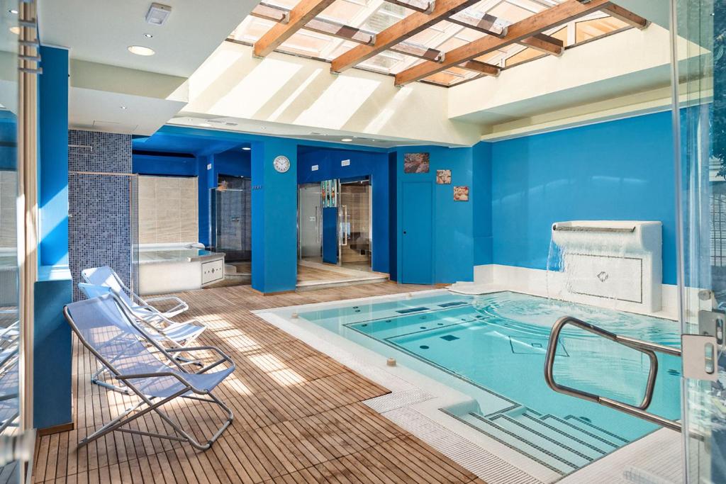 a hot tub in a room with blue walls at Hotel Cavallotti & Giotto in Montecatini Terme