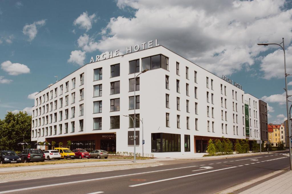 un edificio bianco su una strada con una strada di Arche Hotel Piła a Piła