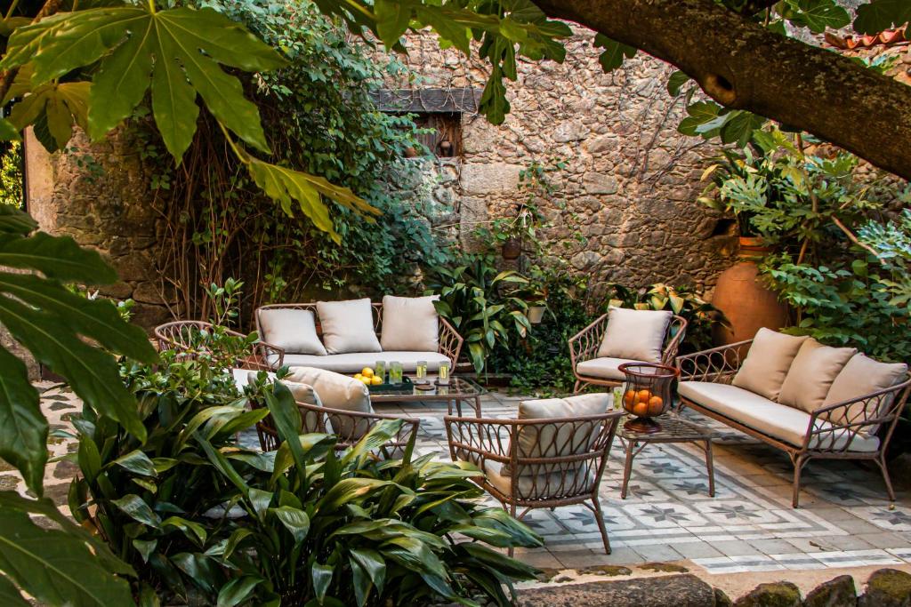 un patio con sillas y mesas en un jardín en TERRACEA, en Hoyos