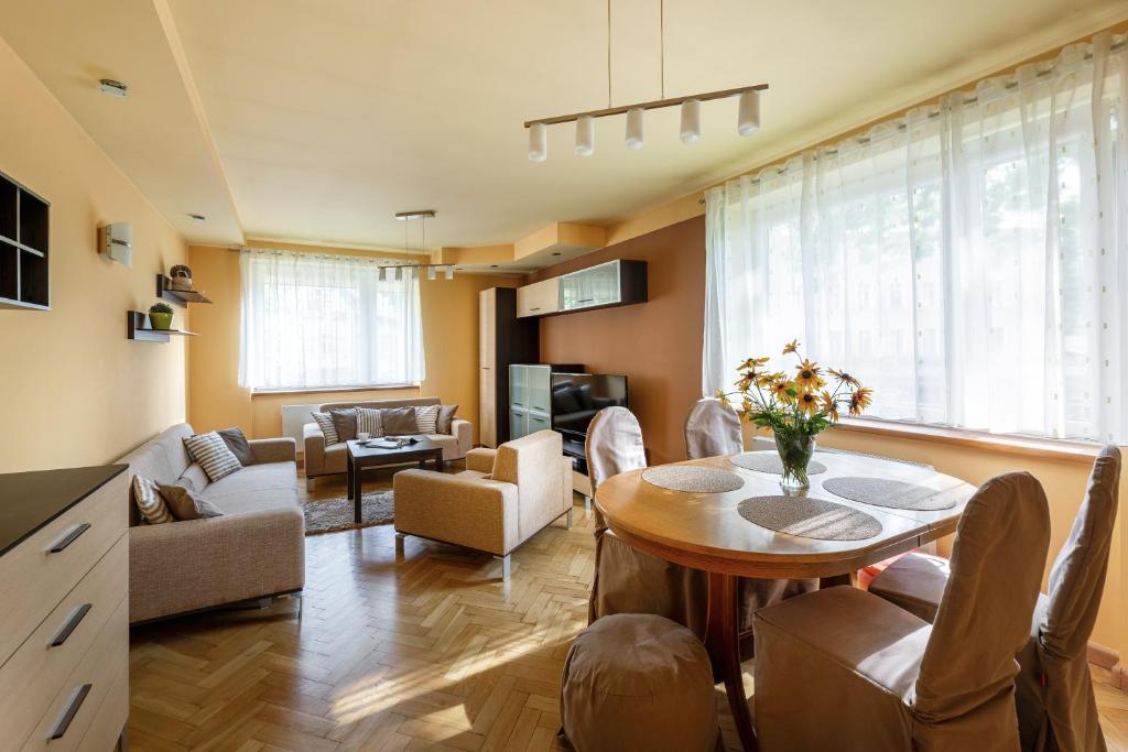 sala de estar con mesa, sillas y sofá en Apartament przy Parku en Kudowa-Zdrój