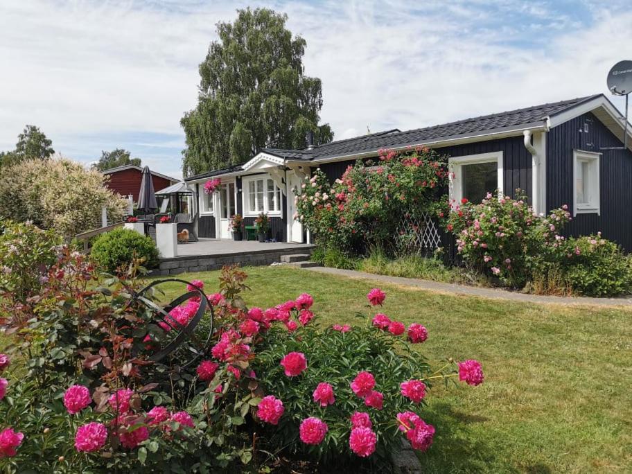 a house with pink flowers in the yard at Trummenäs Golf/Bad/Restaurang in Ramdala