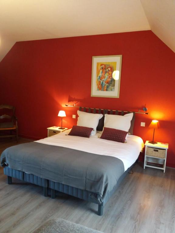 a bedroom with a large bed with a red wall at Escale Au Chiteau in Huisseau-sur-Cosson