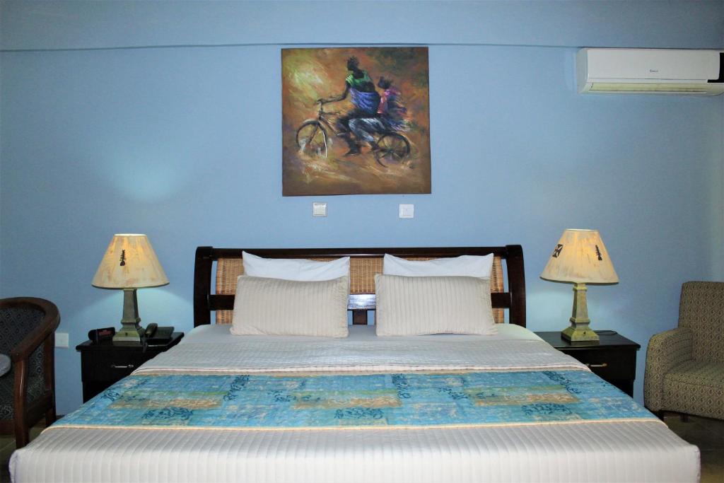 1 dormitorio con 1 cama y una pintura en la pared en Bojo Beach Resort, en Botianaw