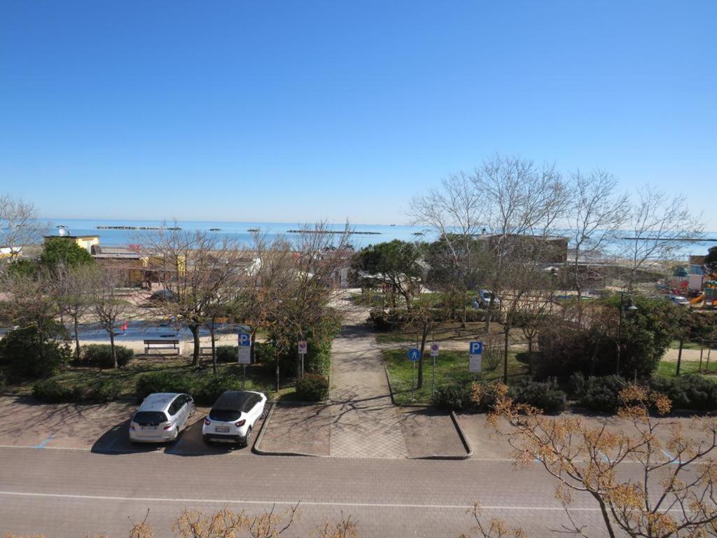 dos autos estacionados en un estacionamiento cerca del agua en Hotel Primula, en Cesenatico