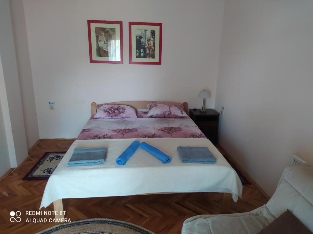 a bedroom with a bed with blue bows on it at Prenoćište Aleksandar in Golubac