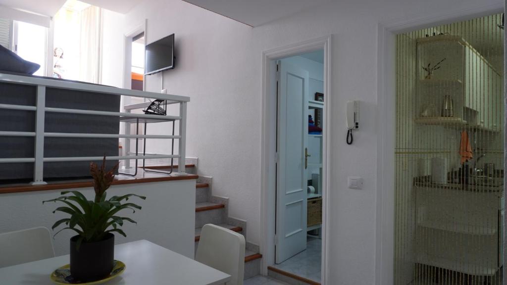 Habitación con mesa y pasillo con escalera. en Apto Magec, en Puerto de Santiago