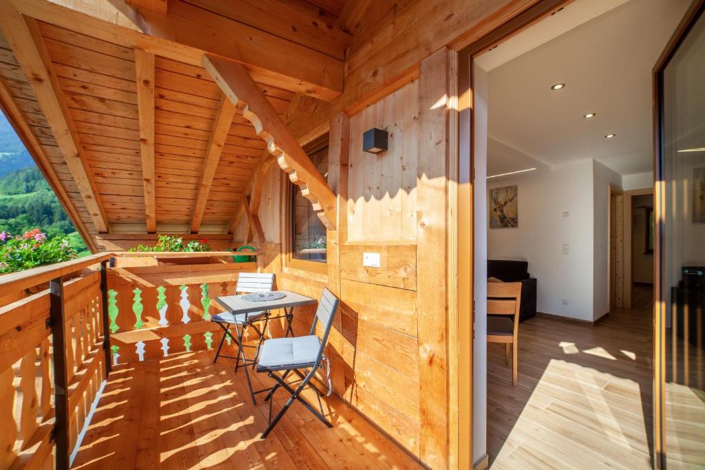 a room with wooden walls and a table on a balcony at Innergasserhof Ferienwohnung Edelweiss in San Martino