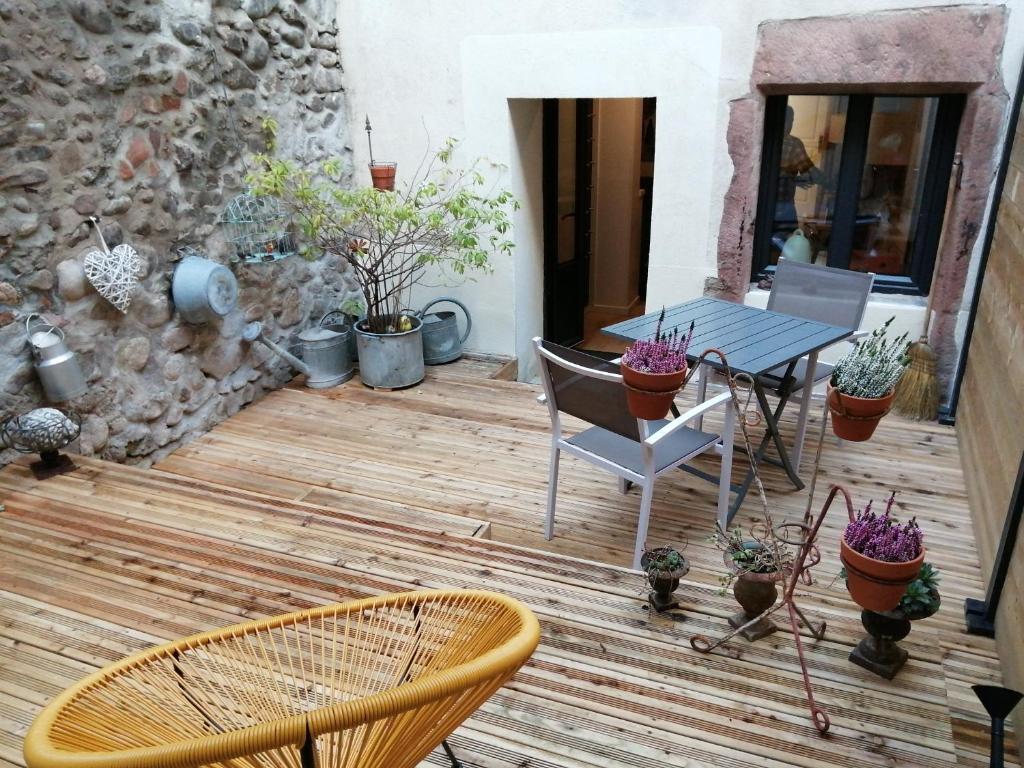a patio with a table and chairs and potted plants at Gîte Le Patio in Kaysersberg