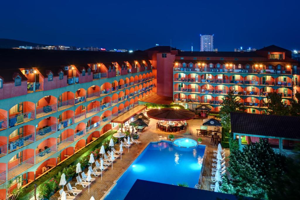 un hotel con piscina por la noche en Hotel Kokiche en Sunny Beach