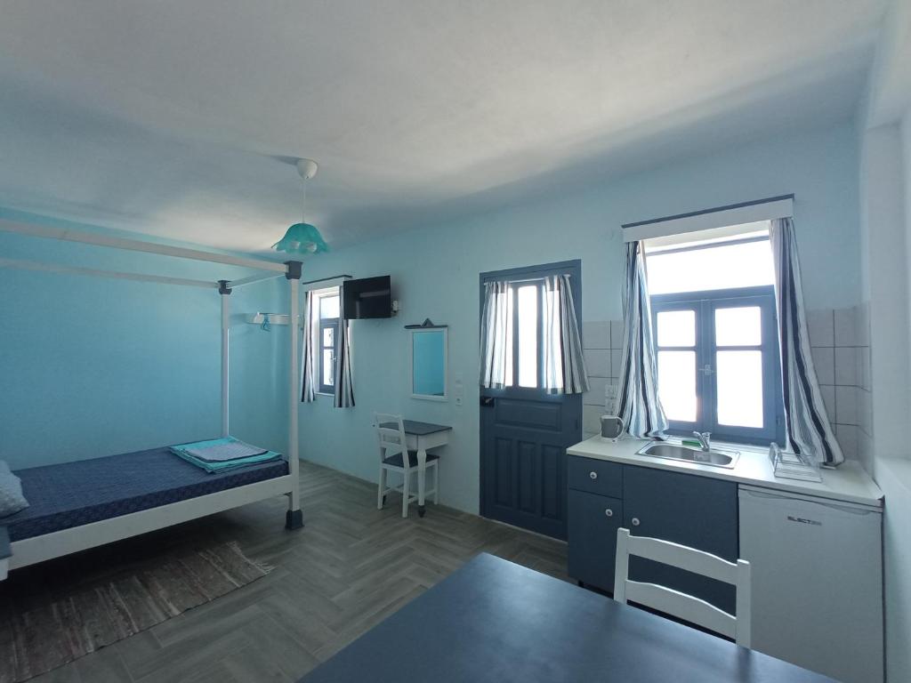 een kamer met een bed, een bureau en een raam bij Anemos Guest House Karpathos in Olympos