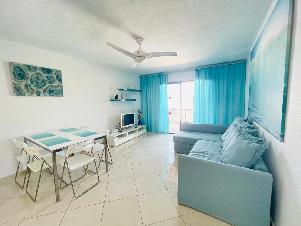 プラヤ・デ・ラス・アメリカスにあるNON Two bedroom apartment in complex Paraiso Royal, LA28のリビングルーム(青いソファ、テーブル付)