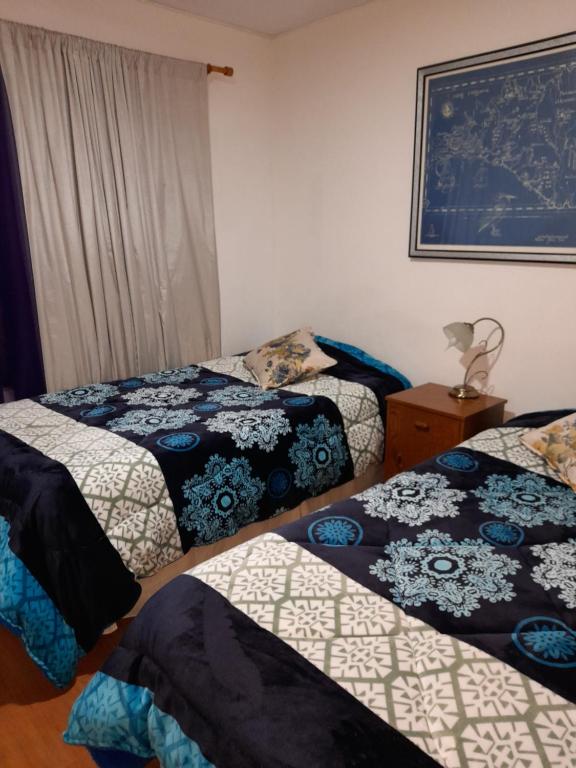 1 dormitorio con 2 camas y una foto en la pared en Alojamiento familiar, habitación o departamento, en Iquique