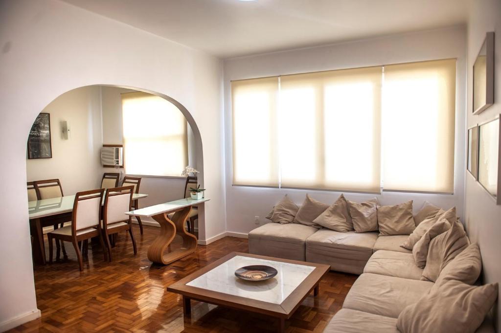 ein Wohnzimmer mit einem Sofa und einem Tisch in der Unterkunft Amazing in Ipanema by Verlaine Adami in Rio de Janeiro