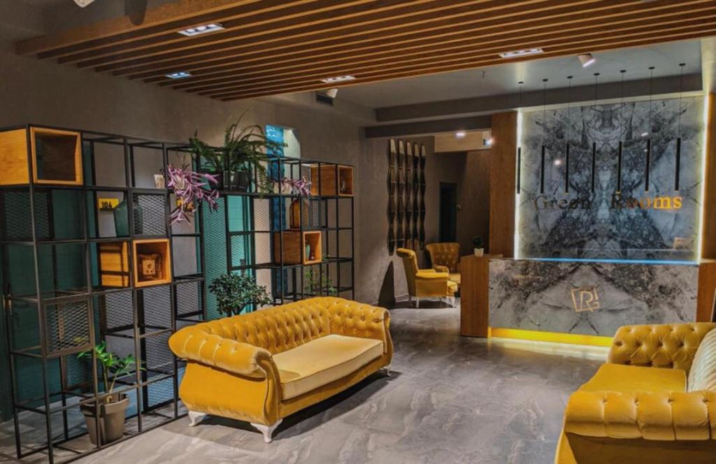 een lobby met een gele bank en stoelen bij Green Rooms in Koetaisi