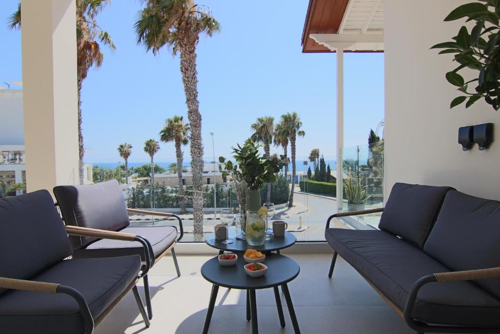 Sala de estar con 2 sofás, mesa y palmeras en Phaedrus Living: Seaview Luxury Flat Limnaria 151 en Pafos