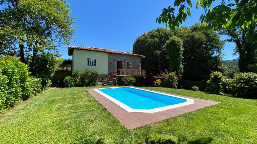 a swimming pool in the yard of a house at Casa de São Vicente de Cima in Póvoa de Lanhoso