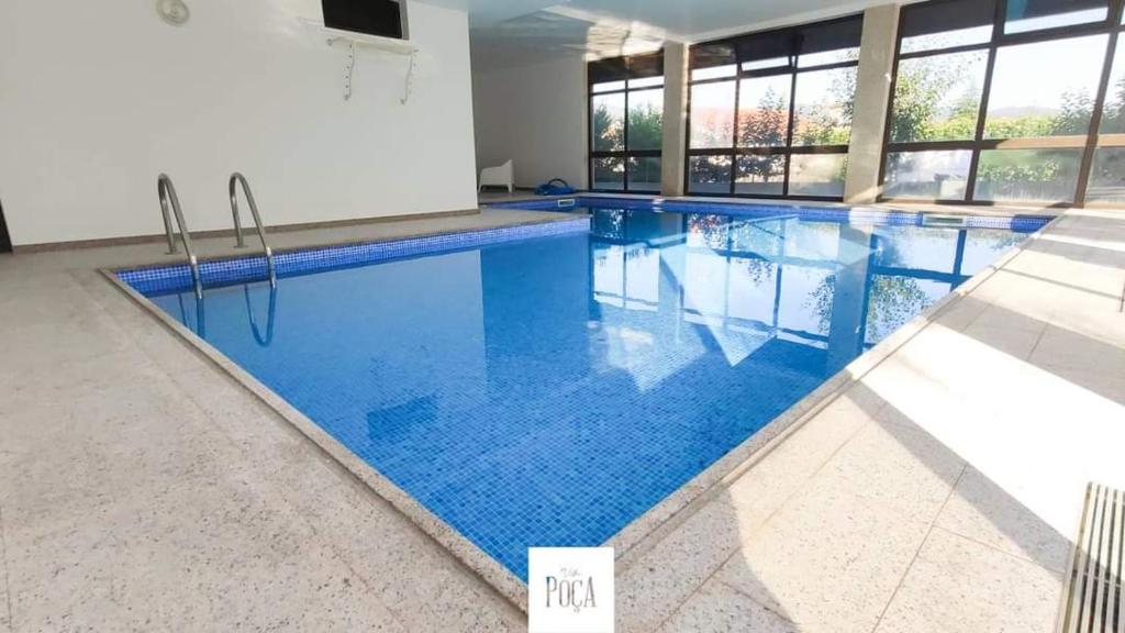 una piscina con acqua blu in un edificio di Villa Poça a Braga