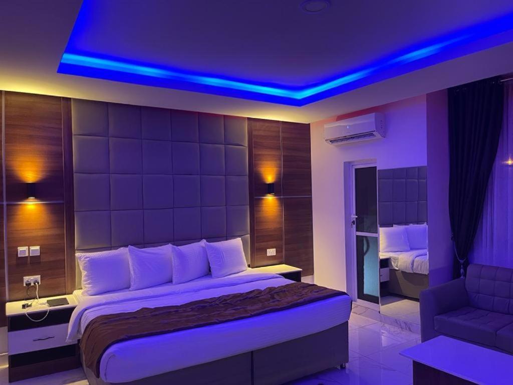 een slaapkamer met een groot bed met blauwe verlichting bij Presken Hotel @Oniru in Lagos