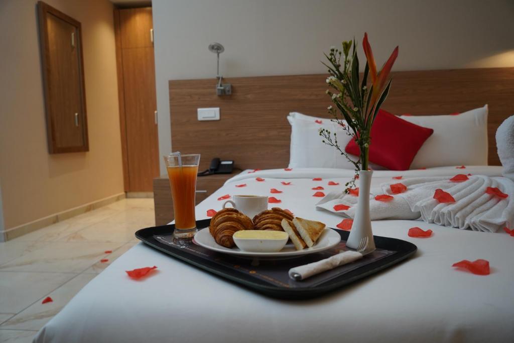 a tray of pastries and drinks on a bed at HOTEL ASTRAL in Abidjan