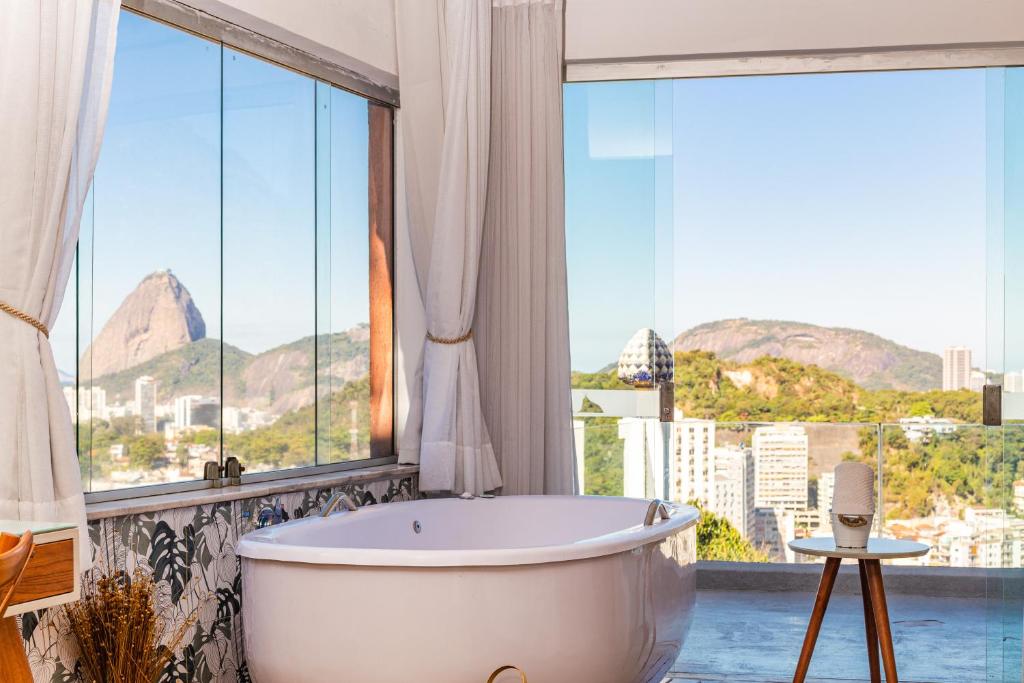 a bath tub in a bathroom with large windows at Santa Vista Rio in Rio de Janeiro