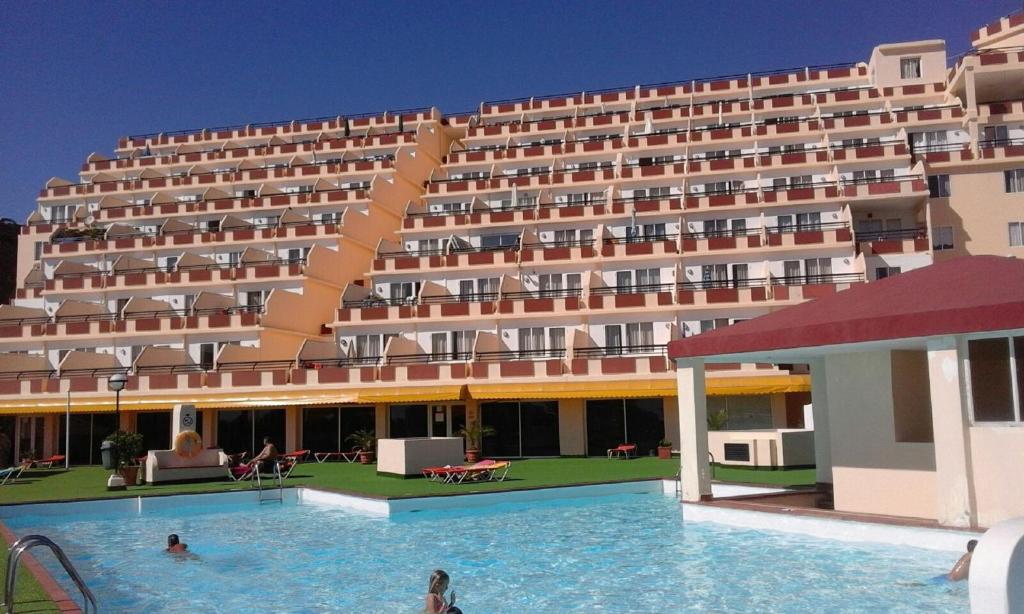a large hotel with a swimming pool in front of it at MIRAMAR ATTICO in Morro del Jable